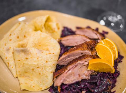 Chrumkavé  kačacie stehno Tiež prsia s kapustou, lokšami a pohárom vína