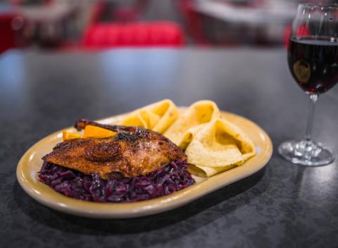 Chrumkavé  kačacie stehno Tiež prsia s kapustou, lokšami a pohárom vína