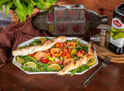 Zeleninový šalát z čerstvých surovín s údeným lososom, olivovým olejom a bagetou.