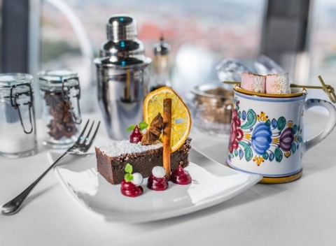 Vyhliadka z UFO s miešaným drinkom, fľašou Prosecca či horúcou čokoládovou tortičkou.