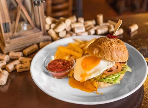 Chrumkavý hovädzí burger s volským okom, slaninou a hranolkami v Českej pivnici.