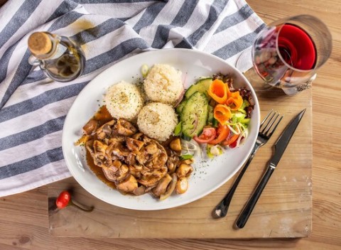 Bravčová panenka s omáčkou z lesných húb a prílohou a pohár vína v Pizza & grill Búdková.